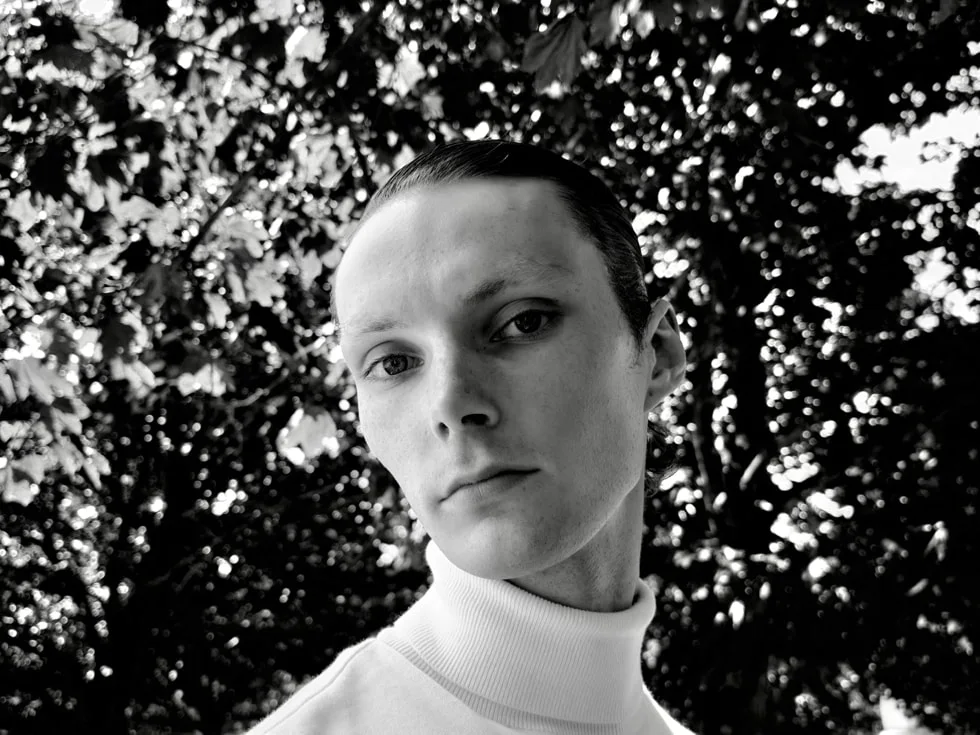 A black-and-white photograph of a person is captured on iPhone 18 Pro.